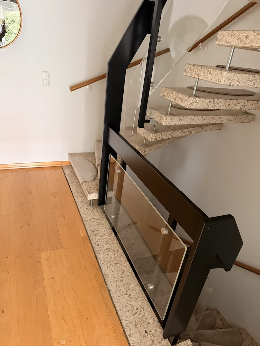 Schwarzes Treppengeländer neben Steinstufen